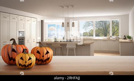 Halloween geschnitzte Kürbisse auf Holztisch. Herbstdekoration über Innenarchitektur-Szene. Klassische Holzküche mit Insel und Hockern Stockfoto