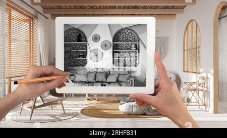 Hände halten und zeichnen auf dem Tablet mit Bohemian Wohnzimmer in Boho-Stil Details CAD-Skizze. Echte fertige Innenausstattung im Hintergrund, Architekt Stockfoto