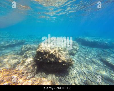 Unterwasserblick auf die Ägäis. Große Felsfragmente im klaren Meer. Weitwinkel Stockfoto