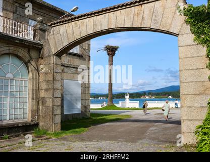 Blick auf die Landschaft durch einen Bogen in Richtung Arousa-Mündung mit einem weiß bemalten urnenförmigen Pflanzgefäß La Toja Island Pontevedra Galicien Spanien Stockfoto