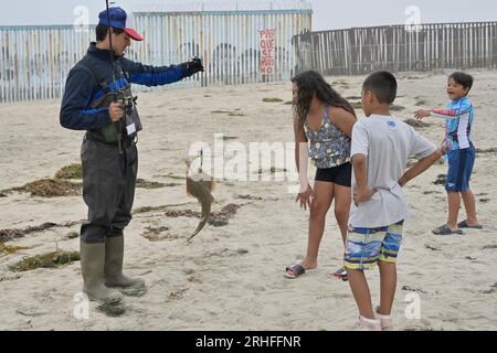 Tijuana, Baja, Kalifornien, Mexiko. 15. Aug. 2023. Ein Mann fischt im Pazifischen Ozean, wo man alte Zäune aus der Ferne der US-mexikanischen Strandgrenze sehen kann. Bauarbeiter haben damit begonnen, einige der primären Zäune am Strand abzubauen, die in den Ozean führen. 30 Fußzaunpaneele werden den älteren Zaun ersetzen. (Kreditbild: © Carlos A. Moreno/ZUMA Press Wire) NUR REDAKTIONELLE VERWENDUNG! Nicht für den kommerziellen GEBRAUCH! Stockfoto