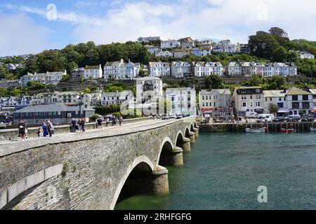 Looe, Großbritannien - August 2023: Blick auf den Hafen und die Bogenbrücke über den East Looe River, die East und West Looe in Cornwall trennen Stockfoto