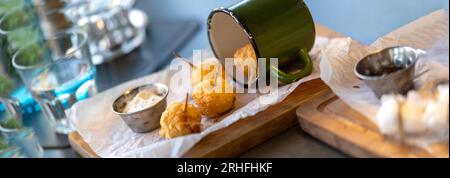 Frittierte Käsebällchen. Käsebällchen in einem altmodischen Becher. Käsebällchen werden in einem Restaurant auf dem Tisch serviert. Stockfoto