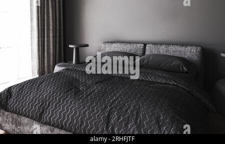 Moderne, dunkle Zimmereinrichtung mit Fenster und Lampe auf dem Tisch. Bett mit grauer Decke und Kissen. Schwarze Wand in der Wohnung. 3D-Rendering. 3D von hoher Qualität Stockfoto