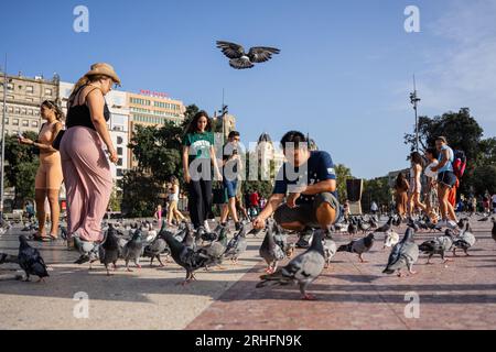 Barcelona, Barcelona, Spanien. 16. Aug. 2023. Eine Gruppe von Touristen macht Fotos mit den Tauben auf der Plaza de Catalunya in Barcelona. In diesem Jahr 2023 wird Spanien den Rekord der Besucher von 2019 brechen. (Kreditbild: © Marc Asensio Clupes/ZUMA Press Wire) NUR REDAKTIONELLE VERWENDUNG! Nicht für den kommerziellen GEBRAUCH! Stockfoto