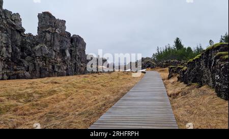 Felsige Bergkette in arktischer Landschaft, thingvellir-Nationalpark mit spektakulären Landschaften und massiven Klippen in island. Felsformationen, die Hügel im isländischen Tal mit Gehweg schaffen. Stockfoto