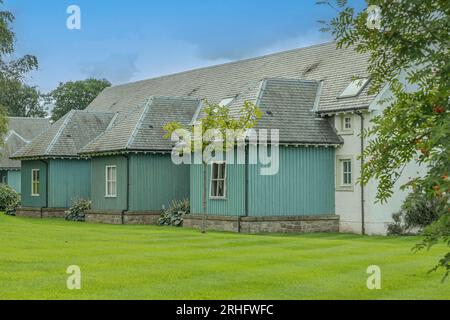 Blick auf die Rückseite einer Reihe schottischer Cottages mit blauen Holzausbauten Stockfoto