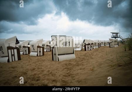 Überdachte Rattan-Liegestühle am ostseestrand, Küste auf der Insel Usedom in Deutschland, Sturm und Regen über dem Brackwasser, hohe Wellen, Stor Stockfoto