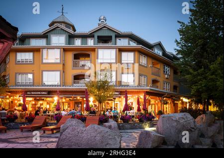 An einem Sommerabend speisen Touristen im Freien auf den Restaurantterrassen im Whistler Village. Whistler BC, Kanada. Stockfoto