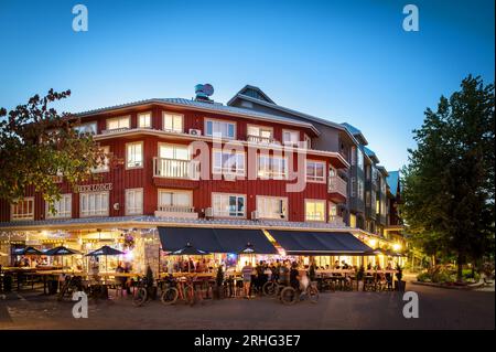 An einem Sommerabend speisen Touristen im Freien auf den Restaurantterrassen im Whistler Village. Whistler BC, Kanada. Stockfoto