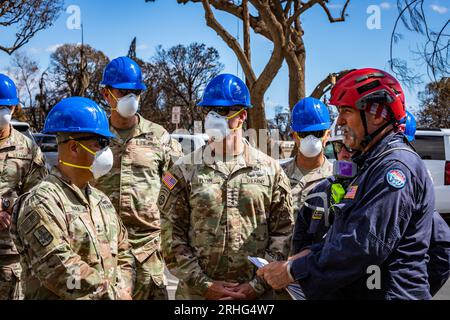 General Charles A. Flynn, Befehlshaber der U.S. Army Pacific, trifft sich am 15. August 2023 neben dem Kommandoelement der Combined Joint Task Force 50 (CJTF-50) mit Such-, Rettungs- und Bergungskräften in Lahaina, Maui, zusammen. Mitglieder der CJTF-50 von der Hawaii Army und Air National Guard sowie der U.S. Army Active Duty and Reserve unterstützen aktiv die Behörden von Maui County bei der sofortigen Sicherheit und dem Wohlergehen der von den Waldbränden betroffenen Personen, um uneingeschränkte Unterstützung für die Gemeinde von Maui und die Ersthelfer zu gewährleisten. Foto von Staff Sgt. Matthew A. Foster/U.S. Arm Stockfoto