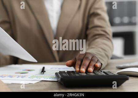 Professioneller Buchhalter, der an einem Holzschreibtisch im Büro arbeitet, Nahaufnahme Stockfoto