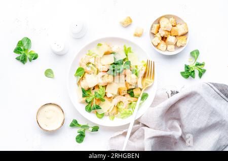 Gourmet-Caesar-Salat mit Garnelen, Eisberg und Salat, Croutons, Parmesan und caesar-Dressing. Weißer Tischhintergrund, Draufsicht Stockfoto