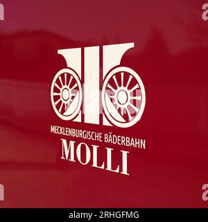 Symbol der Mecklenburgischen Bäderbahn Molli GmbH auf einem roten Wagen der Schmalspurbahn im Bahnhof Heiligendamm in Deutschland Stockfoto