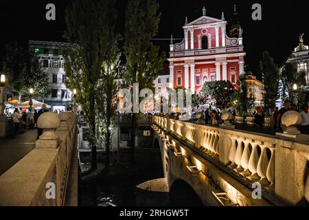 Die Franziskanerkirche in der Altstadt von der Dreifachbrücke aus gesehen - Nacht in Ljubljana, Slowenien Stockfoto