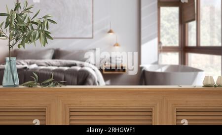 Holztischplatte, Schrank, Platte oder Regal mit Fensterläden aus der Nähe. Olivenzweig in Vase und Kerzen. Verschwommener Hintergrund mit japandischem minimalistischem Schlafzimmer Stockfoto