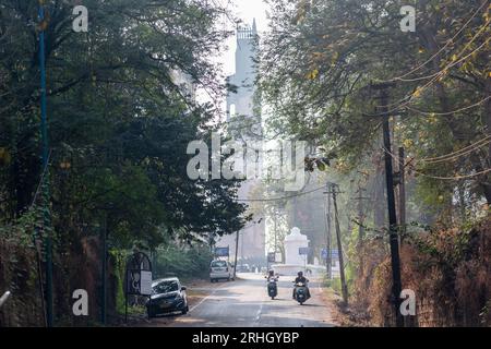 Old Goa, Indien - Januar 2023: Blick auf den Verkehr auf einer Straße in Old Goa mit dem alten St. Augustinenturm im Hintergrund. Stockfoto