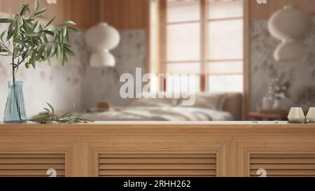 Holztischplatte, Schrank, Platte oder Regal mit Fensterläden aus der Nähe. Olivenzweig in Vase und Kerzen. Verschwommener Hintergrund mit japandischem Schlafzimmer aus Holz, innen Stockfoto