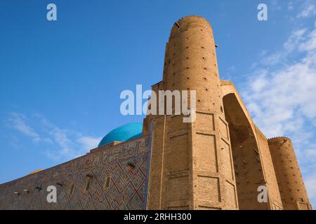 Nachmittagsblick auf das linke Minarett an der Vorderfassade. Im Timirud-Stil, dem Wahrzeichen der Seidenstraße, befindet sich das Khoja Ahmed Yasawi Mausoleum in Turkestan Stockfoto