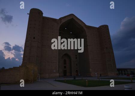 Der Blick auf die Fassade ist von einem aufragenden, stimmungsvollen, unruhigen, unheimlichen Ausblick direkt nach Sonnenuntergang. Im Timirud-Stil, der berühmten Stätte der Seidenstraße, dem Khoja Ahmed Yasawi Ma Stockfoto