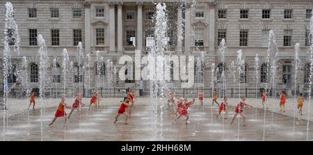 Somerset House, London, Großbritannien. Aug. 2023. 22 Tänzerinnen in leuchtend orangen Kostümen, die von Ursula Bombshell entworfen wurden, tanzen in den Springbrunnen des Somerset House in einer Kostümprobe für Shobana Jeyasinghs Kontrapunkt. Am Wochenende des 19-20. August werden acht Aufführungen von Kontrapunkt stattfinden, die Teil des Somerset House’s Summer in the Courtyard und des Inside Out Festivals des Westminster City Council sind. Quelle: Malcolm Park/Alamy Live News Stockfoto