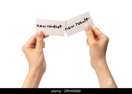 Neue Denkweise - neuer Ergebnistext auf einer Karte in einer Frauenhand isoliert auf weißem Hintergrund. Stockfoto
