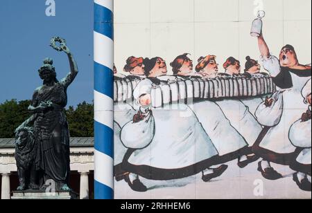 München, Deutschland. Aug. 2023. Die Bavaria-Statue steht auf dem Oktoberfestgelände hinter dem Wandgemälde eines Bierzeltes. Das 188. Oktoberfest findet in diesem Jahr vom 16. September bis zum 03. Oktober 2023 statt. Quelle: Peter Kneffel/dpa/Alamy Live News Stockfoto