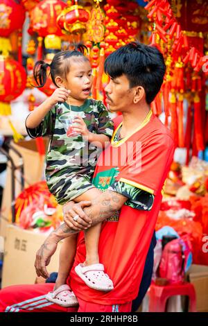 Ein stolzer junger Thai-Vater spielt mit seiner schönen kleinen Tochter in China Town, Bangkok, Thailand. Stockfoto