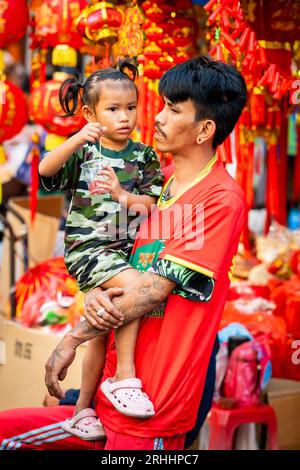 Ein stolzer junger Thai-Vater spielt mit seiner schönen kleinen Tochter in China Town, Bangkok, Thailand. Stockfoto