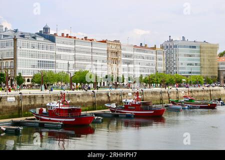 Fischerboote liegen im Hafen mit Gebäuden entlang der Avenida Marina A Coruña Galicien Spanien vor Stockfoto