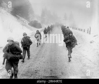 BEI MURRINGEN, BELGIEN - 31. Januar 1945 - marschieren US-Truppen der 1. Division durch Schnee in Richtung Murringen, Belgien, nach einem großen deutschen Verein Stockfoto