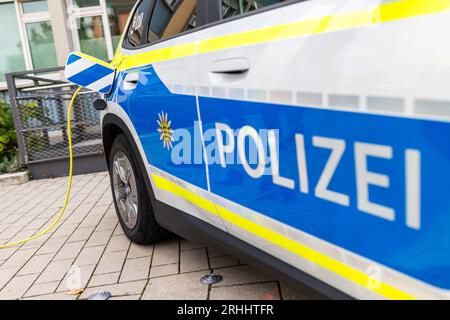 Kehl, Deutschland. Aug. 2023. ABBILDUNG: Ein Ladekabel wird in ein batteriebetriebenes Polizeifahrzeug eingesteckt. Seit Januar 2023 setzt die Polizei Baden-Württemberg 47 rein batteriebetriebene Autos und Transporter für allgemeine Geschäfts-, Transport- und Logistikaufgaben sowie 17 Einsatzfahrzeuge mit Plug-in-Hybridantrieb ein. Für eine klimaneutrale Polizeiflotte testet das Innovation Lab der Polizei Kehl derzeit vier Elektrofahrzeuge für den Betrieb 24/7. Quelle: Philipp von Ditfurth/dpa/Alamy Live News Stockfoto