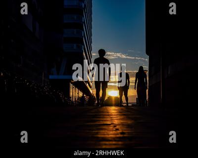 Nijmegen, Gelderland, Niederlande. August 2023. Ein Blick auf die Silhouetten von drei Personen, die während des Sonnenuntergangs gehen. Nach einigen wechselhaften Wochen können sich die Niederlande auf das Sommerwetter in dieser Woche freuen. Die Temperaturen sind gestiegen und es gibt viel Platz für Sonnenschein. In den folgenden Tagen bleibt es meist trocken und die Sonne scheint ausgiebig, so dass Temperaturen zwischen 22 und 28 Grad zu erwarten sind. (Bild: © Ana Fernandez/SOPA Images via ZUMA Press Wire) NUR REDAKTIONELLE VERWENDUNG! Nicht für kommerzielle ZWECKE! Stockfoto