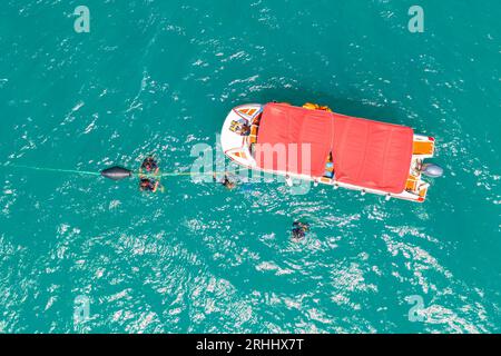 Boot mit Taucheranzug und Flossen im Meer kam in der Lagune an, um nach unten zu tauchen, von oben aus Stockfoto