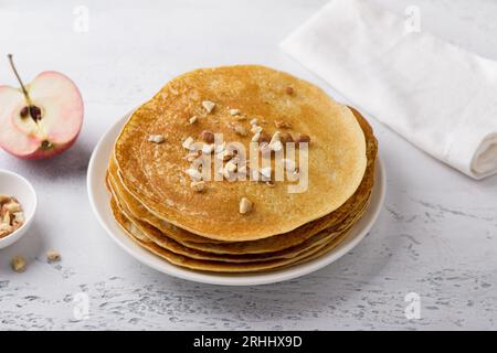 Apfelpfannkuchen mit Nüssen auf hellgrauem Hintergrund, Draufsicht. Köstliches hausgemachtes Essen. Stockfoto