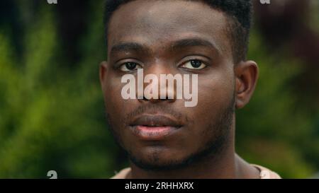 Nahaufnahme männliches Gesicht ernsthafter tausendjähriger junger afroamerikanischer ethnischer Mann schönes Porträt trauriger ruhiger starker Mann in der Stadt draußen, der auf die Kamera schaut Stockfoto