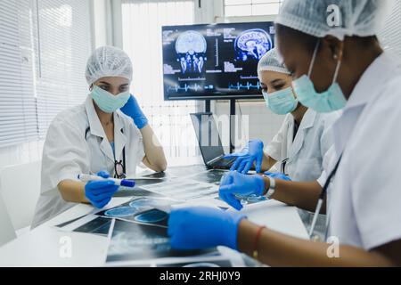 Das Ärzteteam überprüft die Ergebnisse des Scans und schaut sich Monitore im Labor an, teilt medizinisches Wissen und Erfahrungen, von denen ihre Mitarbeiter profitieren Stockfoto