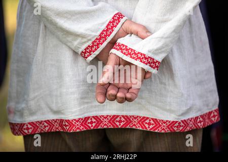 Hände eines einheimischen Mannes in seto estnischer Volkstracht gekleidet zur Feier des estnischen Nationalfeiertags namens Jaanipaev oder leedopaev, Estland Stockfoto