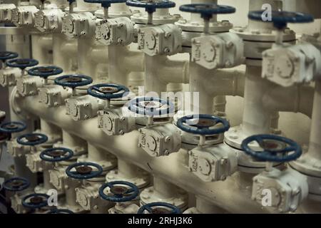 Drosselklappenverteiler im Motorraum für den Transport von Treiböl zur Ladung mit blauen Ventilgriffen. Stockfoto