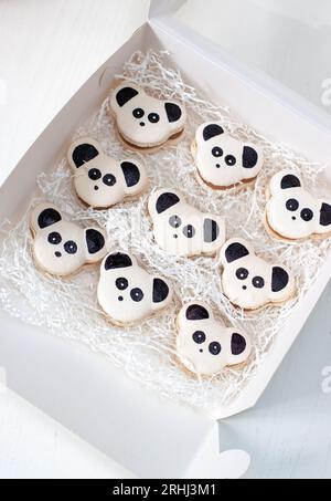 Schwarz-weiße Macarons oder Kekse im Panda-Design in Geschenkbox. Ein süßes Geschenk zum Geburtstag des Babys Stockfoto