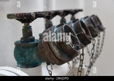 Rostiger Löschwasserverteiler aus Messing für Offshore-Behälter mit Handventilgriffen zum Anschluss an den Wasserschlauch an Deck. FFS-feste Löschanlage. Stockfoto