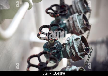 Rostiger Löschwasserverteiler aus Messing für Offshore-Behälter mit Handventilgriffen zum Anschluss an den Wasserschlauch an Deck. FFS-feste Löschanlage. Stockfoto