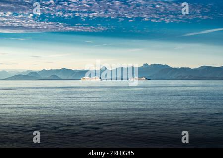 Zwei Kreuzfahrtschiffe fahren durch die Golf-Inseln von British Columbia mit Blick auf die Sunshine Coast in der Nähe des Campbell River bei einem dramatischen Sonnenuntergang Stockfoto