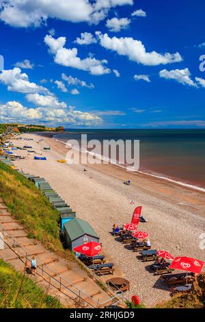 Bunte Boote am Strand von Budleigh Salterton mit Blick auf die Mündung des Flusses Otter und der Landzunge Otterton Ledge, Devon, England, Großbritannien Stockfoto