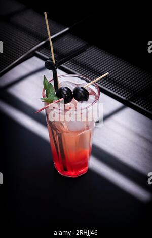 Ein erfrischender Gin-Fizz-Cocktail mit frischen Kirschen und Limettensaft Stockfoto