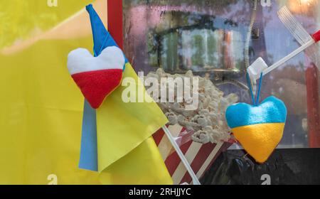 Die Flaggen Polens und der Ukraine bilden eine Herzform. Demonstration zur Unterstützung der Ukraine bei einem Straßenessen-Festival. Stockfoto