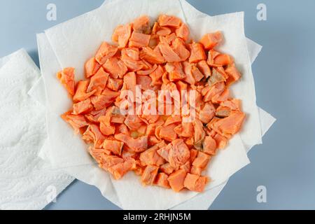 Getrockneter marinierter Lachs beim Ceviche: Lachsstücke auf einem mit Papierhandtuch ausgelegten Teller werden trocken getupft Stockfoto