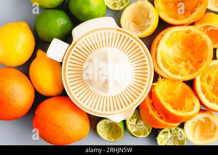Elektrischer Entsafter umgeben von Zitrusfrüchten von oben: Ein elektrischer Entsafter umgeben von ganzen und saftigen Orangen, Limonen und Zitronen Stockfoto
