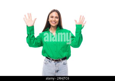 Fröhliches junges, braunhaariges weibliches Model mit braunen Augen in einem grünen Hemd Stockfoto