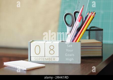 September. Bild des hölzernen Kalenders vom 8. september auf dem Desktop. Herbsttag. Zurück zur Schule. Bleistifte und Farben, Schreibwaren Stockfoto